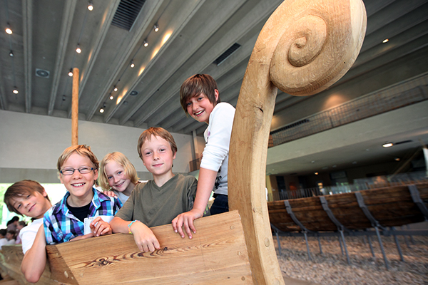 Teaser Pressebild 4: Kinder erkunden einen Teilnachbau der Römerboote.