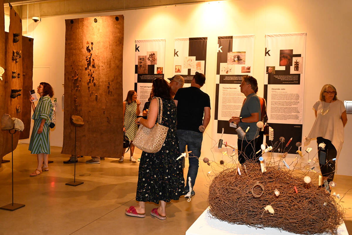 Gäste flanieren durch die Ausstellung.